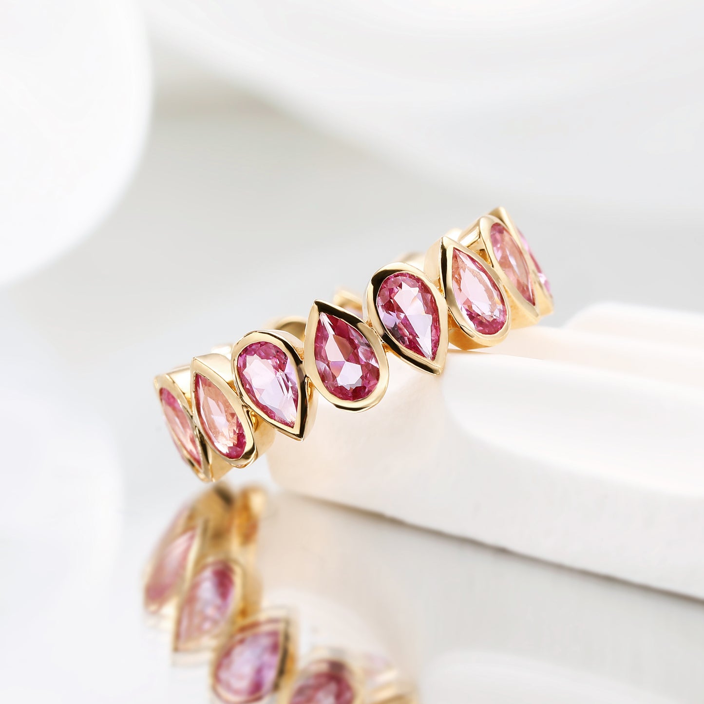 Bezel set Lab Grown Pink Sapphire 3x5 pear shaped eternity band ring in gold
