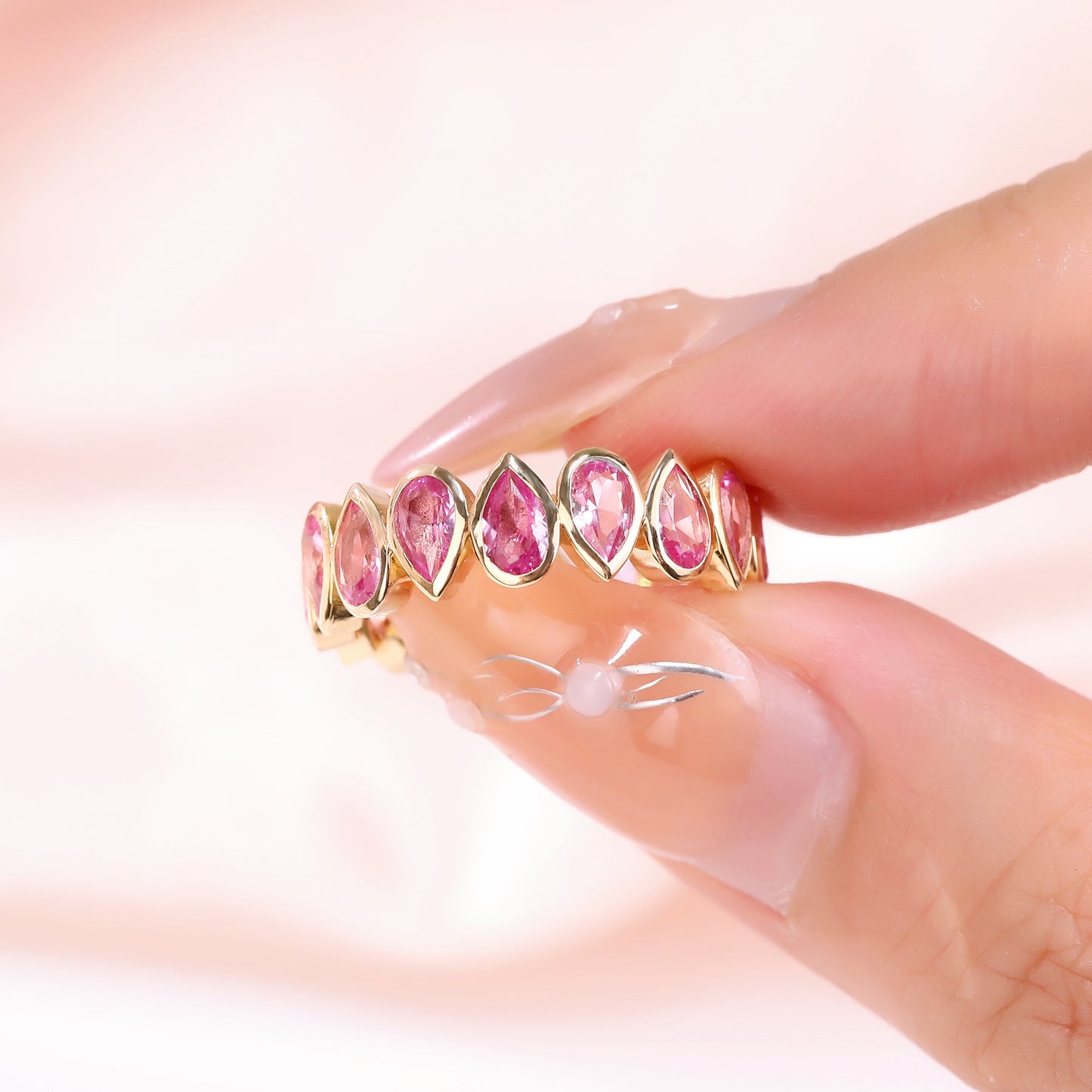 Bezel set Lab Grown Pink Sapphire 3x5 pear shaped eternity band ring in gold