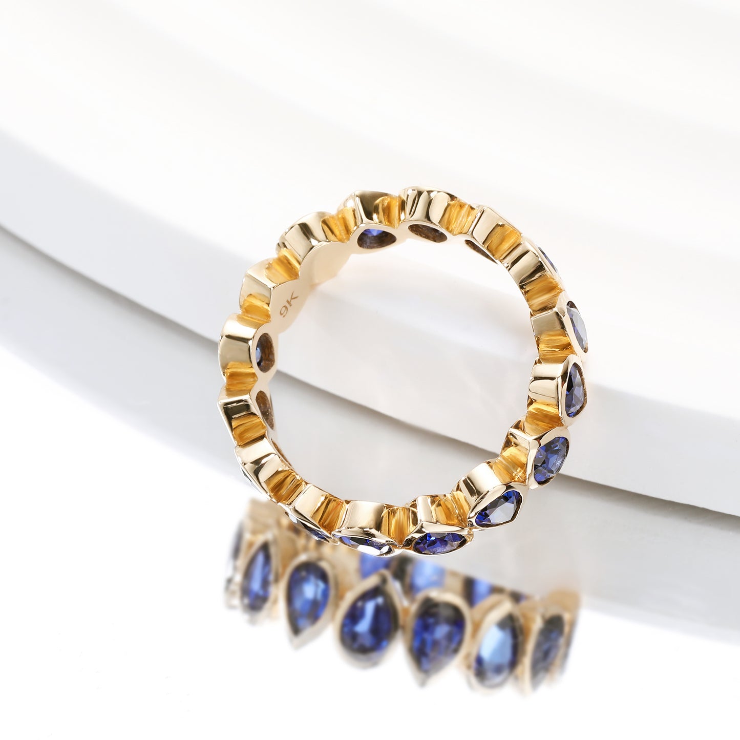 Bezel set Lab Grown Sapphire Royal Blue 3x5 pear shaped eternity band ring in gold