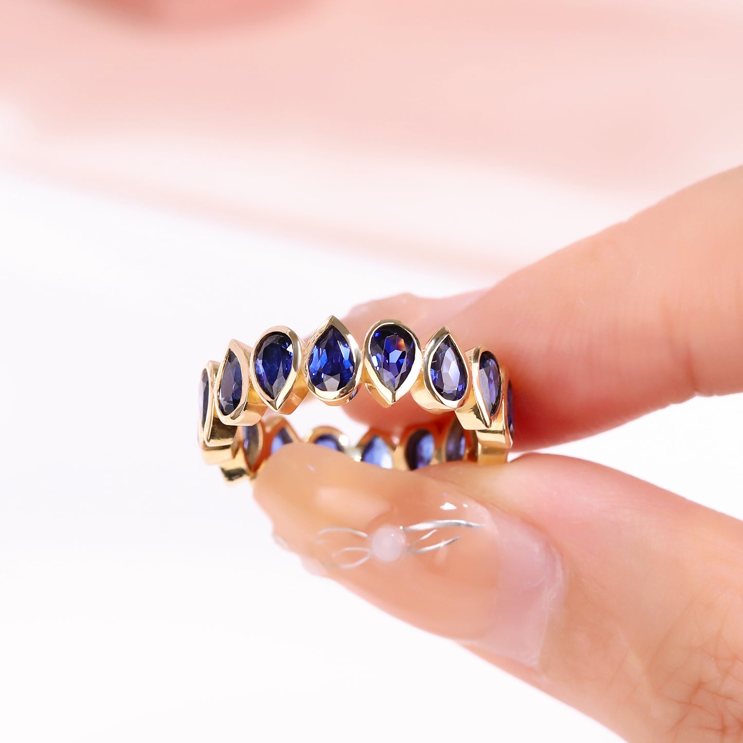 Bezel set Lab Grown Sapphire Royal Blue 3x5 pear shaped eternity band ring in gold