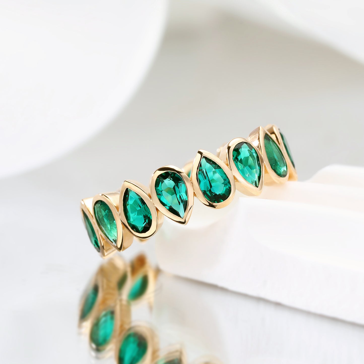 Bezel set Lab Grown Emerald 3x5 pear shaped eternity band ring in gold